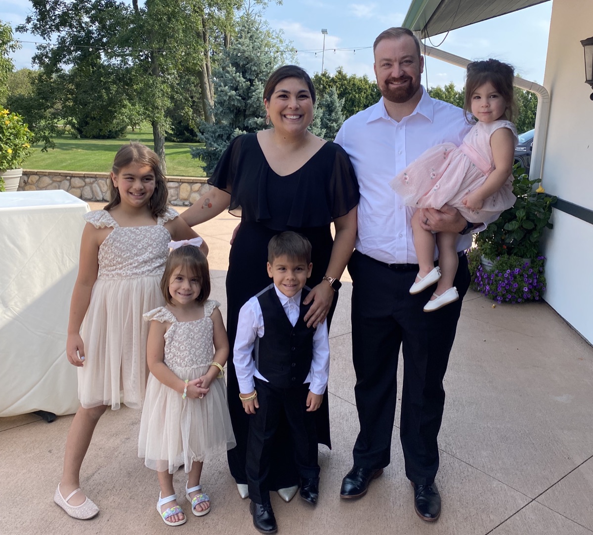 Daniel with his wife and four kids, dressed up at a wedding